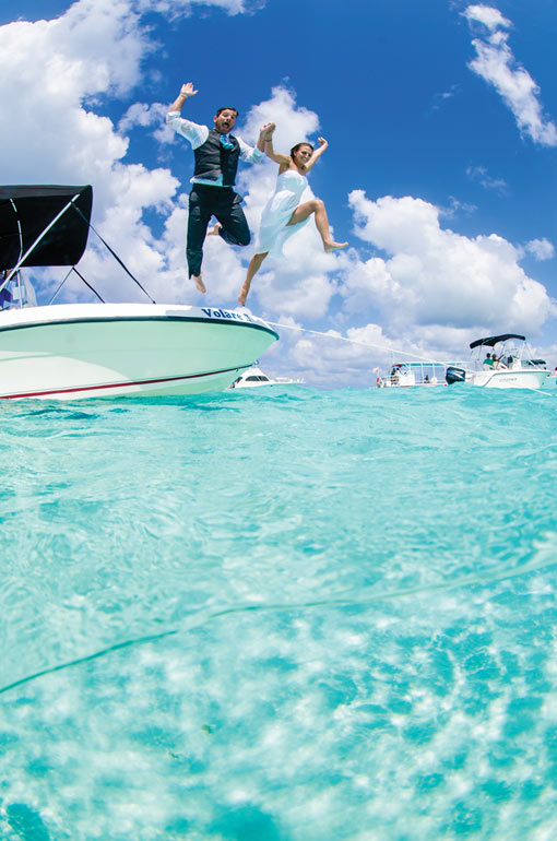 Couple jumping of the boat